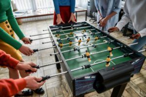 Friends playing foosball football table